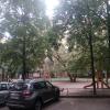 Стоя спиной к подъезду.